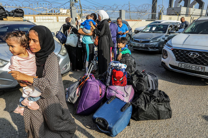 Palestinians with foreign passports wait to cross the Rafah Border Gate into Egypt.
