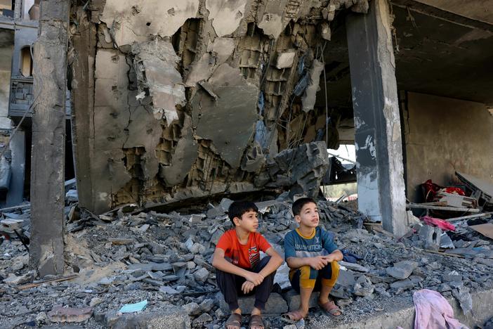 Children sit amid the rubble of a building in the aftermath of an Israeli strike in Rafah in the southern Gaza Strip on Friday.