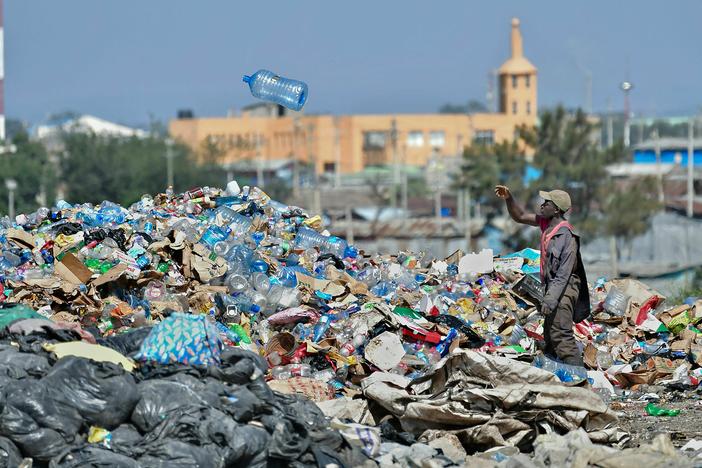 A man picks through plastic waste at a garbage dump in Kenya.