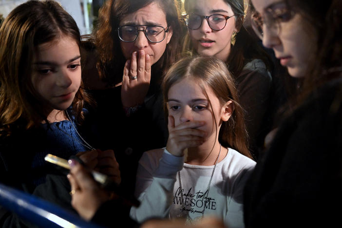 A mother and her children react to the news that Hanna Katzir, who the Palestine Islamic Jihad claimed died in captivity, is among the 13 Israelis released. They are watching the news on their phone outside the Museum of Tel Aviv on Friday.