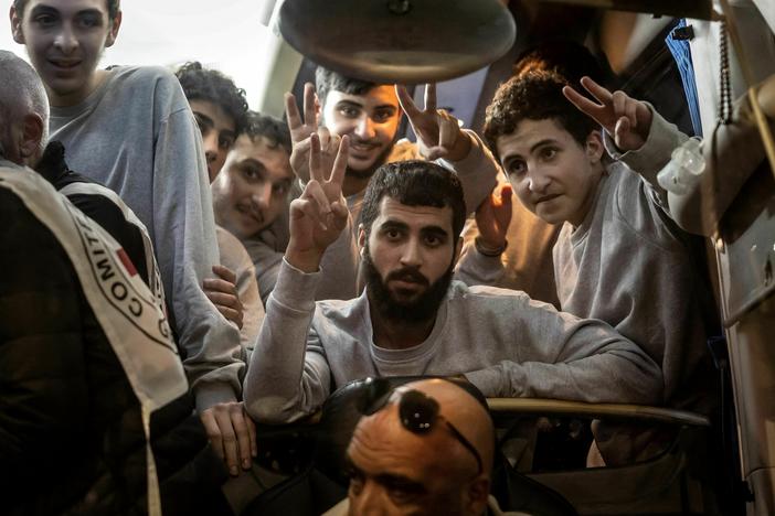 People gesture from a Red Cross bus carrying Palestinian prisoners released from Israeli jails in exchange for hostages released by Hamas from the Gaza Strip, in Ramallah, in the occupied West Bank, on Sunday.