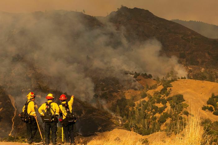 Firefighters survey the fire during operations to battle the Kincade Fire in Healdsburg, Calif., on Oct. 26, 2019.