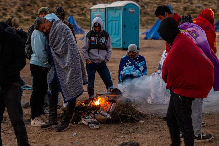 Migrants huddling for warmth at an unofficial detention camp in Jacumba, Calif.