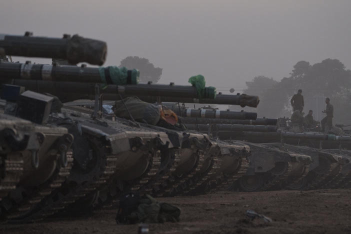 Israeli soldiers stand on top of a tank in a staging area at the Israeli-Gaza border in southern Israel, on Monday.