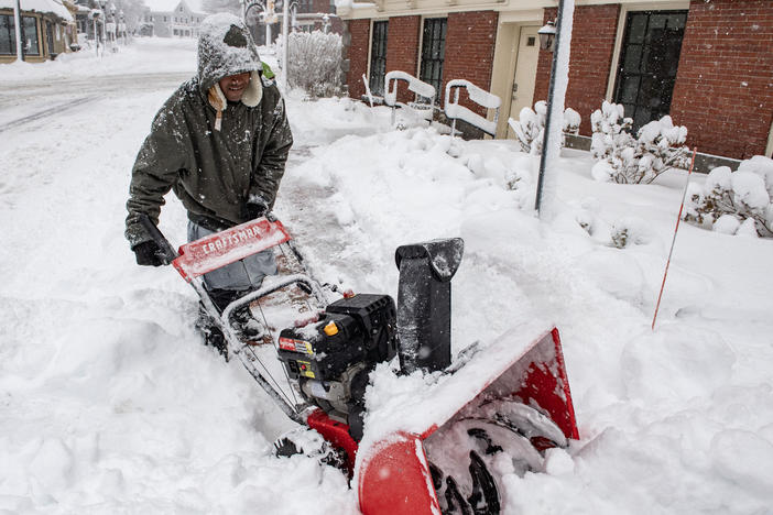 A person uses a snowblower to clear snow in front of a home in Methuen, Mass., on Sunday.