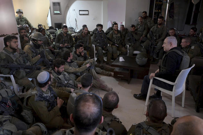 Israel's Prime Minister Benjamin Netanyahu (right) speaks to soldiers on a visit to the northern Gaza Strip on Dec. 25, 2023. Netanyahu says the militant group Hamas must be destroyed in the current war in Gaza, though some critics say that goal is unrealistic.