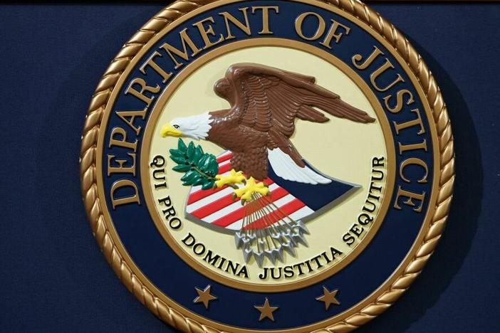 The U.S. Department of Justice seal is seen on a lectern.