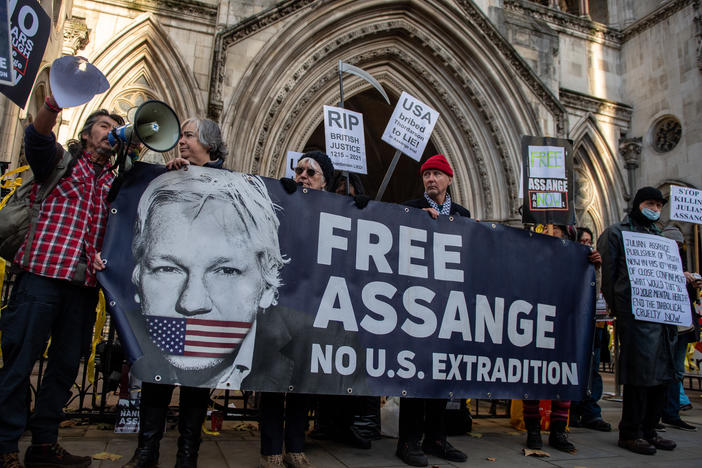 Julian Assange supporters hold up a banner that says "Free Assange No U.S. Extradition" outside the Royal Courts of Justice in London in Dec. 2022.