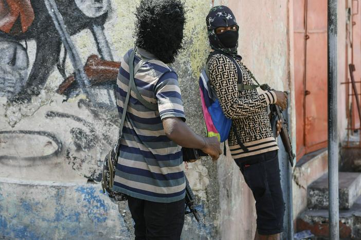 Members of the G9 and Family gang stand guard at their roadblock in the Delmas 6 neighborhood of Port-au-Prince, Haiti, Monday, March 11.