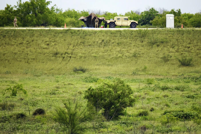 Two members of the National Guard patrol an area of land behind the federal border wall Tuesday evening, March 19in Mission, Texas.