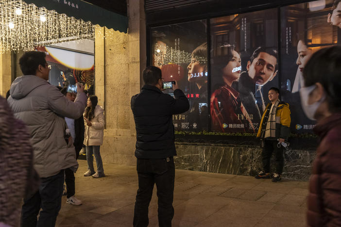 Visitors take photographs in front of posters of the TV show Blossoms Shanghai at the Peace Hotel, in Shanghai, China, on Friday, Jan. 12, 2024. Director Wong Kar-wai's First TV Series 'Blossoms Shanghai' evokes memories of a more open and optimistic period in China.