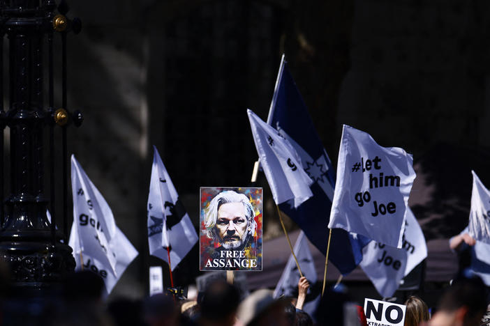 Supporters of WikiLeaks founder Julian Assange, fly a banner featuring an image of Assange, as they protest in support of him, outside The Royal Courts of Justice, Britain's High Court, in central London on Monday.