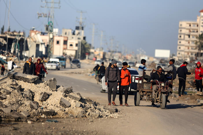 Palestinians walk along Salah al-Din Road in Deir Al-Balah, in the central Gaza Strip.