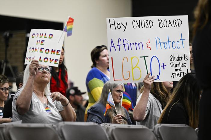 Parents, students, and staff of Chino Valley Unified School District hold up signs in favor of protecting LGBTQ+ policies at Don Antonio Lugo High School, in Chino, Calif., in June 2023. California Gov. Gavin Newsom signed a law Monday barring school districts from passing policies that require schools to notify parents if their child asks to change their gender identification.