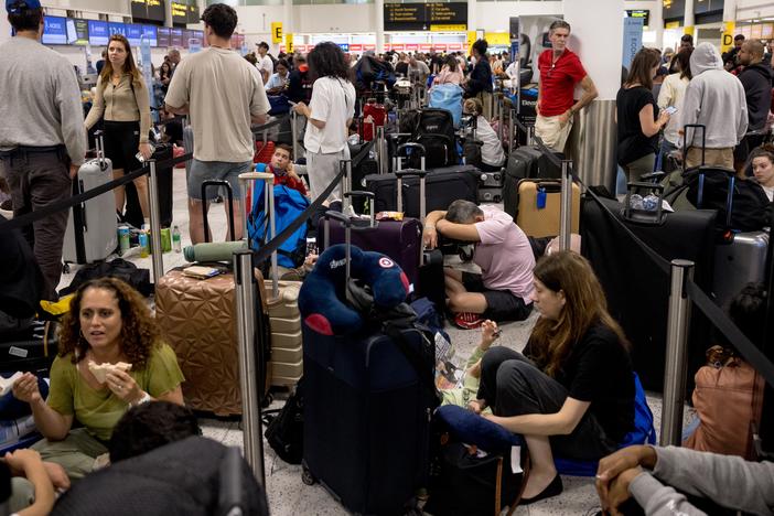 Passengers line up at London's Gatwick Airport amid a global IT outage on Friday.  