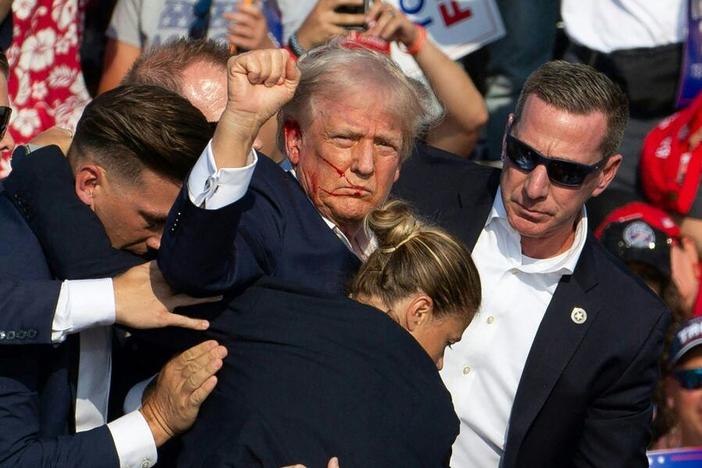 Republican candidate Donald Trump is surrounded by Secret Service agents following an attempted assassination attempt in in Butler, Pa., on July 13. The head of the Secret Service will appear before lawmakers Monday to discuss the agency's actions before, during and after the incident.