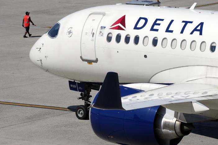 Some airline issues continued Monday after a faulty software update caused technological havoc worldwide and resulted in several carriers grounding flights, but the number of flights impacted is declining. Here, a Delta Air Lines jet leaves the gate on Friday at Logan International Airport in Boston.