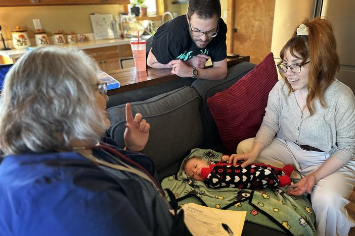 Barb Ibrahim, left, drove half an hour to visit Amber and Matt Luman and their new daughter, Esserley. Ibrahim, a nurse of more than 30 years, is part of new program in Oregon that offers free home visits from a registered nurse for any family with a newborn.