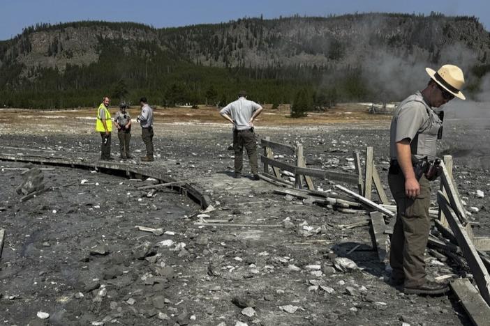 In this photo released by the National Park Service, park staff assess the damage to Biscuit Basin boardwalks after a hydrothermal explosion at Biscuit Basin in Yellowstone National Park, Wyo., on Tuesday.