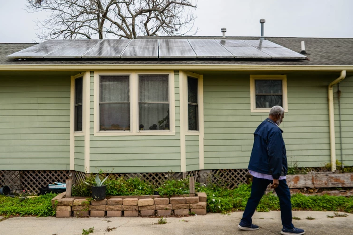 Rev. Charles Duplessis walks by his solar panel-topped house in New Orleans' Lower Ninth Ward neighborhood on Friday, Feb. 25, 2022. The Environmental Protection Agency this week awarded the city nearly $50 million to help pay for installing solar on low to middle income homes.