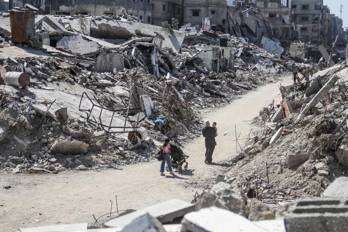 People stand amid rubble in the Jabalia refugee camp, northern Gaza Strip, on July 21.