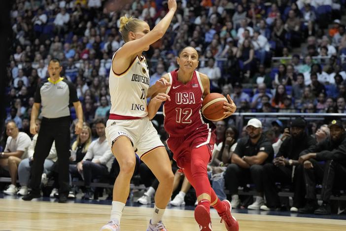 United States' Diana Taurasi (right) drives around Germany's Leonie Fiebich during a women's exhibition basketball game between the United States and Germany in London on July 23, 2024.