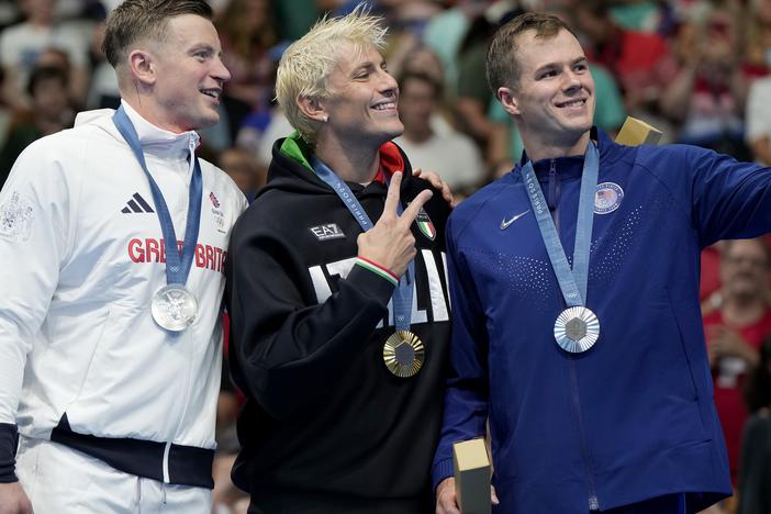 Adam Peaty, left, of Great Britain, tested positive for COVID on Monday, a day after he stood with Gold medalist Nicolo Martinenghi, center, of Italy, and dual silver medalist Nic Fink, of the United States. The men competed in the 100-meter breaststroke final at the 2024 Paris Olympics in Nanterre, France.