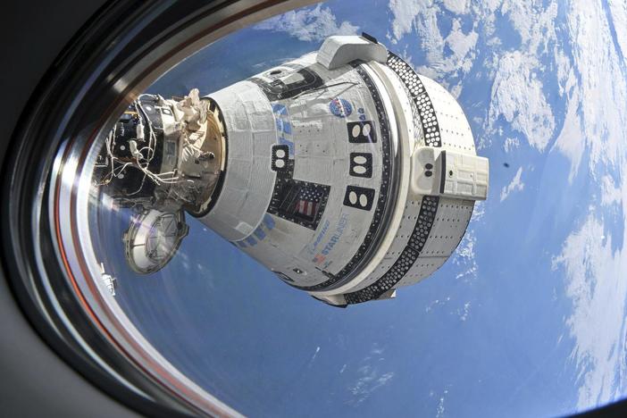 This photo provided by NASA shows Boeing's Starliner spacecraft docked to the Harmony module's forward port on July 3, seen from a window on the SpaceX Dragon Endeavour spacecraft docked to the adjacent port. 