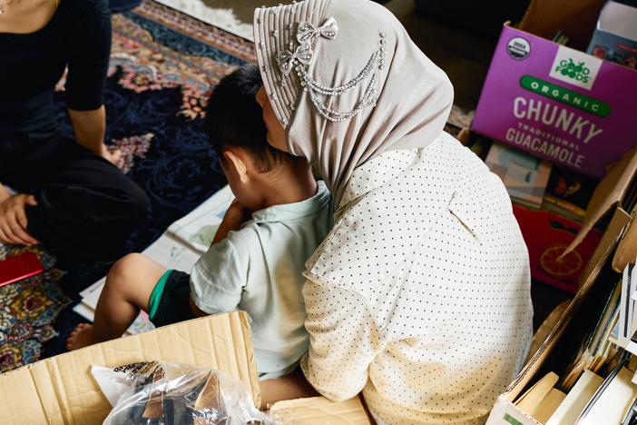 A mother and her young son sit in the playroom of a house that offers temporary shelter for migrants in Queens, N.Y. They both crossed into the U.S. without authorization in the past year.