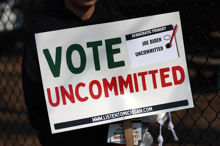 An "uncommitted" voter holds a sign opposing President Biden’s policy toward Israel’s war in Gaza, outside a polling place in Dearborn, Mich., ahead of that state's presidential primary in February.