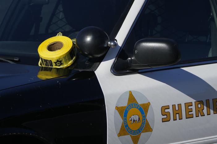 A roll of police tape is left on the windshield of a Los Angeles County sheriff's vehicle. Federal prosecutors allege two former Los Angeles County Sheriff's Department officers took part in an elaborate extortion scheme.