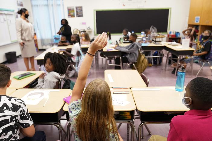 A student raises their hand in a classroom at Tussahaw Elementary school Aug. 4, 2021, in McDonough, Ga.