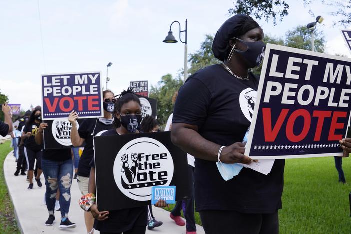 Supporters of restoring Florida felons' voting rights march to an early voting precinct on Oct. 24, 2020, in Fort Lauderdale, Fla.