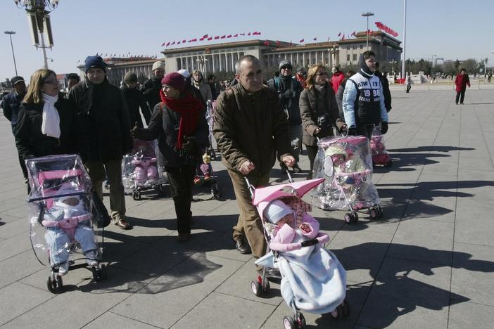 Spanish couples take their newly adopted Chinese children for a walk in Beijing's Tiananmen Square, March 7, 2007. 