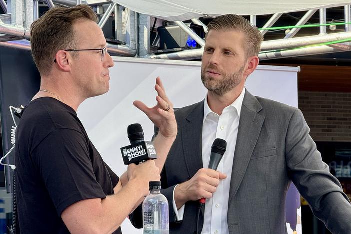 Political commentator and YouTuber Benny Johnson (left) speaks with Eric Trump, a son of former President Donald Trump, during the 2024 Republican National Convention in Milwaukee. Johnson made videos for Tenet Media. The Justice Department accused a company matching Tenet's description of working closely with employees of Russian state broadcaster RT to covertly spread pro-Russian narratives in the United States. Johnson says he was not aware of Tenet's ties to Russia.