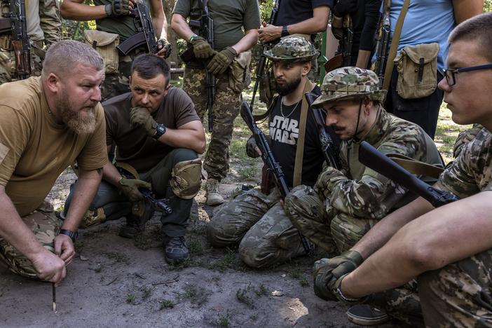 Ukrainians discuss the tactics of working in small groups at the military training called "Test Week" for civilians provided by one of the most successful units of Ukraine’s Armed Forces, the 3rd Separate Assault Brigade, in Kyiv, Ukraine, on Aug. 7. Its aim is to give civilians a sense of what they will experience if they are conscripted or decide to enlist in military service.