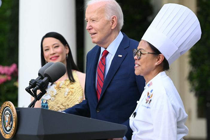 President Biden welcomes then White House executive chef Cristeta Comerford to the podium during a reception celebrating Asian American, Native Hawaiian and Pacific Islander Heritage Month in May.