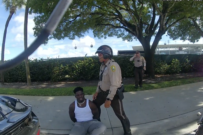 This screen capture from bodycam footage of Miami-Dade Police shows an officer detaining Miami Dolphins player Tyreek Hill following a traffic stop on Sunday.