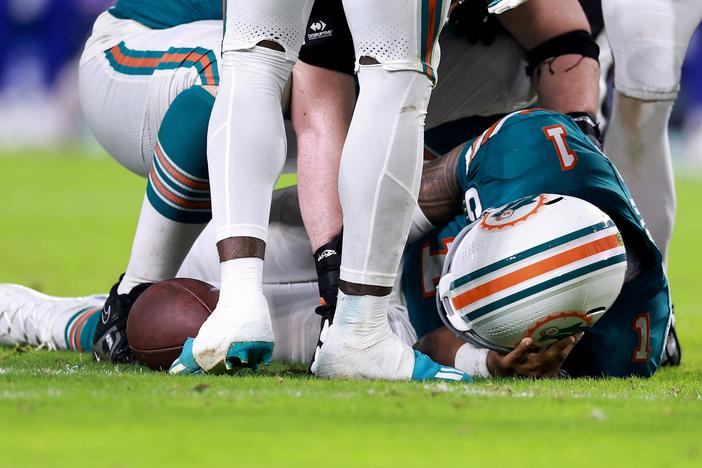 Miami Dolphins quarterback Tua Tagovailoa lays on the ground after colliding with a Bills defender during a Thursday night game. 