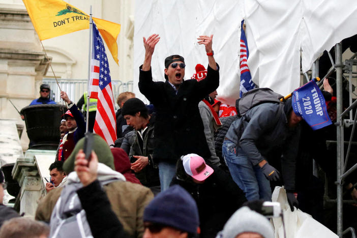 A man, identified as Ryan Kelley in a sworn statement by an FBI agent, gestures as supporters of U.S. President Donald Trump make their way past barriers at the U.S. Capitol during a protest against the certification of the 2020 U.S. presidential election results by the U.S. Congress, in Washington, U.S., January 6, 2021. REUTERS/Jim Urquhart