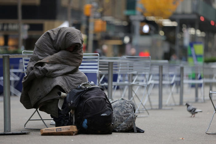 A person sits on Broadway, after New York City Mayor Eric Adams announced that homeless people deemed to be in psychiatric crisis can be involuntarily hospitalized, in Manhattan, New York City, U.S., December 1, 2022. REUTERS/Andrew Kelly