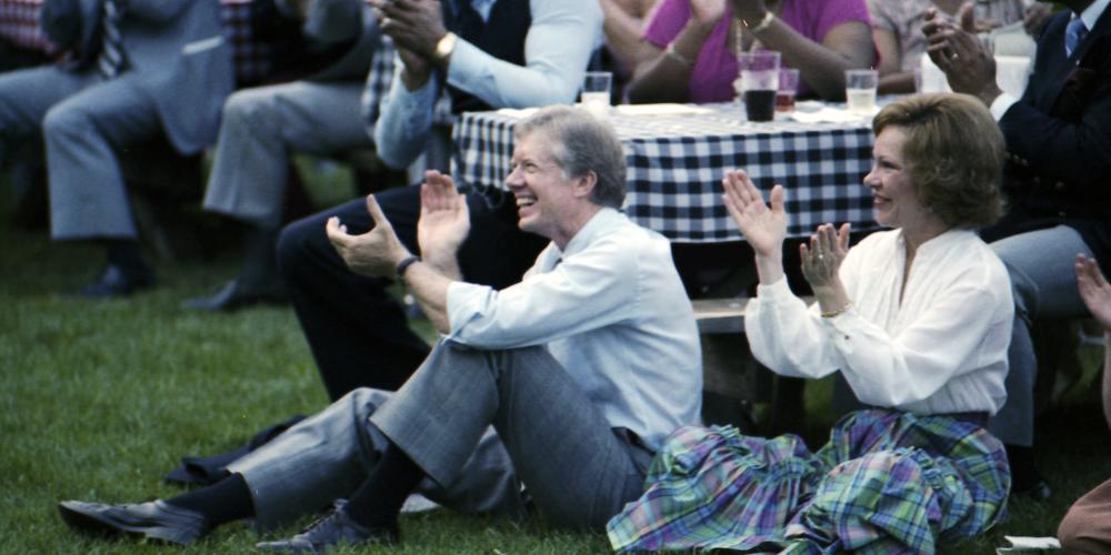 Jimmy and Rosalynn Carter sitting on lawn enjoying the show.