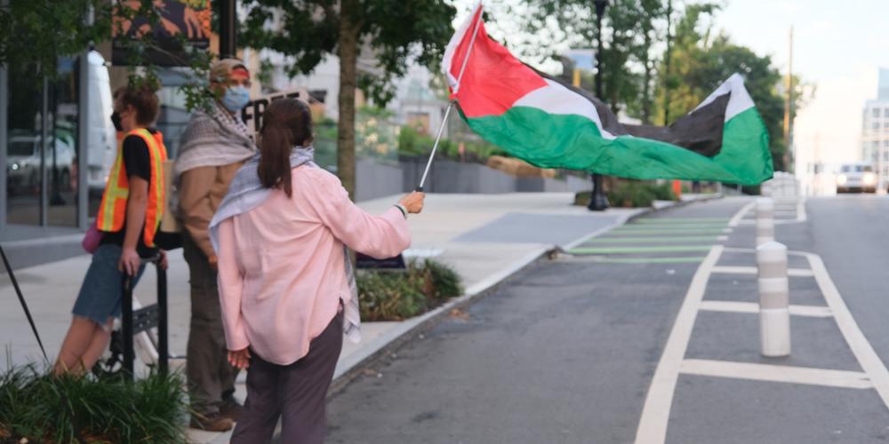 A person waves a Palestinian flag on 10th St. in Atlanta, Ga., on June 27, 2024.