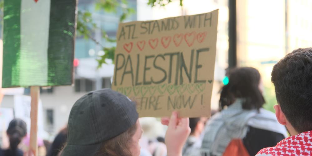 A protestor holds signage in support of Palestine rally in midtown Atlanta on June 27, 2024.