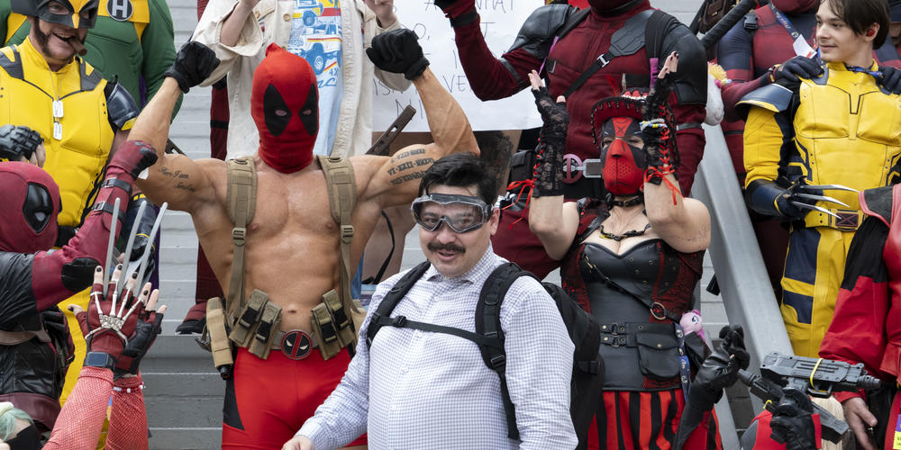 Deadpool cosplayers cheer for a Peter cosplayer during a photo op at Dragon Con 2024.