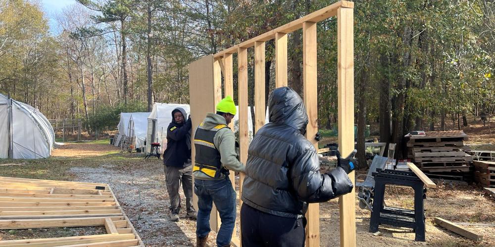 Participants work to build a shed for workshops at Phoenix Gardens.