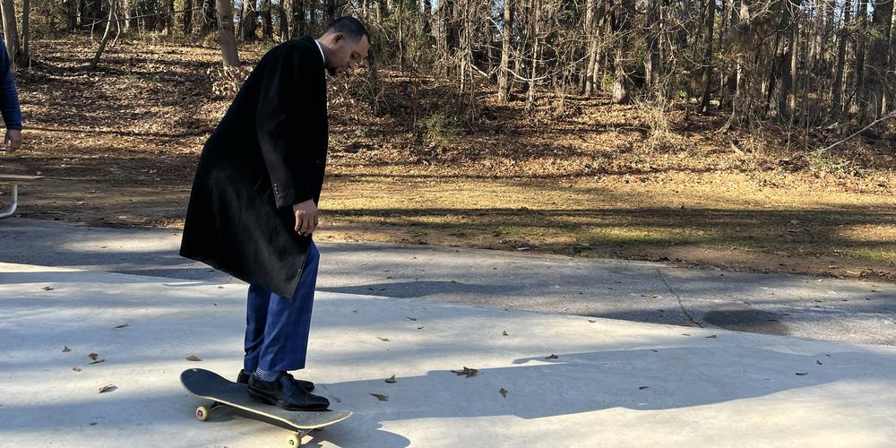 Atlanta City Councilman Antonio Lewis gets on a skateboard after the official ribbon cutting on Ruby Harper Skatepark.