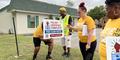 Canvassers with IMAN Atlanta place a yard sign in front of a church in Augusta.